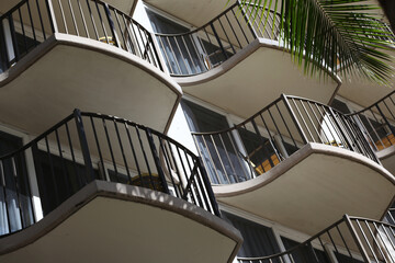 Fototapeta premium Small balconies with palm frond on tropical apartments, hotel or resort