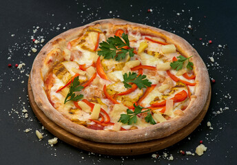 Traditional Italian pizza with ham, cheese and tomatoes on a dark background