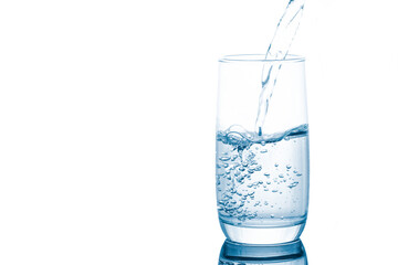 Spring water pouring into glass isolated on white background.