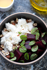 Salad with feta cheese, beetroot, chopped hazelnuts and fresh beetroot leaves, closeup, vertical shot