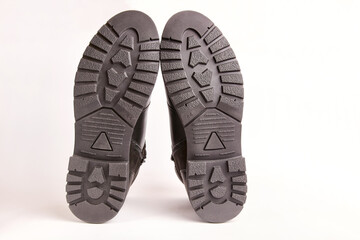 Soles of black leather men's boots on a white background.