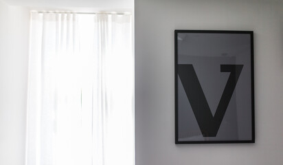 V letter in a frame on the wall