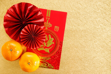 Chinese new year festival decoration with red bags, oranges and red Chinese folded fans on golden background.
