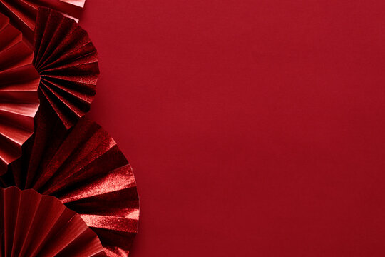 Chinese new year festival decoration with red Chinese folded fans on red background.