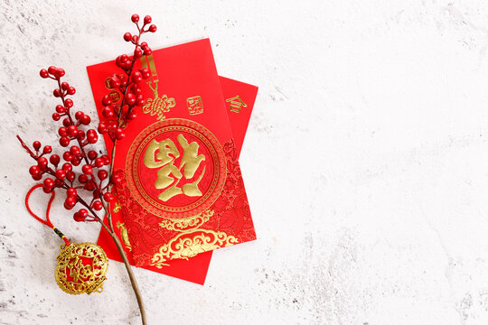 Chinese new year festival decorations with red bags, oranges and red Chinese folded fans on white marble table background.