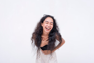 A young woman having a hard time containing her laughter. Bursting into a raucous laugh. Isolated on a white backdrop.