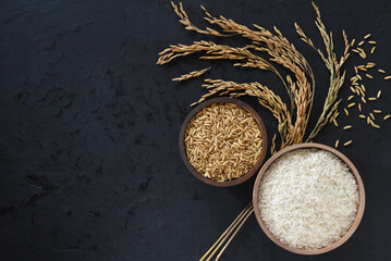 Paddy and rice in baskets placed on a black background with ears of rice.