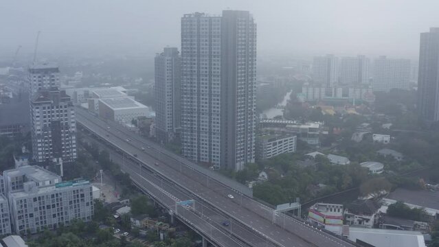Foggy and cloudy drone birds eye scene revealing Sukhumvit street in Bangkok, the capital of Thailand. City landscape. City skyline 4K. Cityscape skyline.