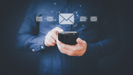 Email Marketing and Newsletters, Technology and lifestyle concepts. Man's hand using smartphone or mobile phone and sending online message with email icon.