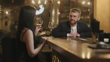man and woman have nice evening in bar, drinking wine and talking, first date after acquaintance