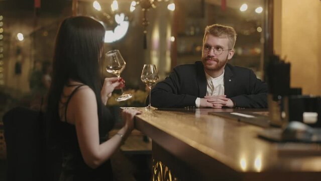 man and woman have nice evening in bar, drinking wine and talking, first date after acquaintance