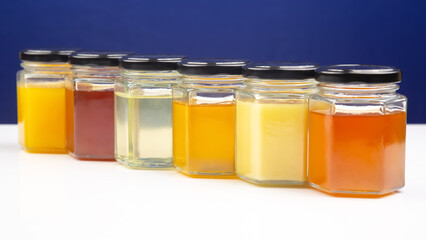 Hexagonal jars with different types and colors of fresh flower honey. vitamin food for health and life