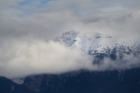 Landscape image of mountain top covered by snow and clouds