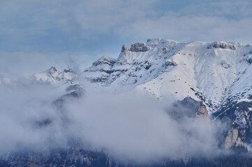 Landscape image of mountain top covered by snow and clouds