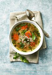 Spelt soup with carrot and fresh parsley. Top view - 557687361