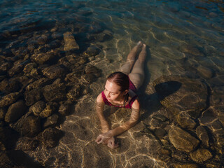 female tourist wearing swimsuit relaxing in sea at beach near ancient city Phaselis, Kemer Antalya province Turkey. ancient port city with beach and ruins of ancient Roman baths, theaters, aqueducts