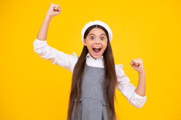 Teenager child overjoyed successful do winner gesture clench fist say yes isolated on yellow background studio. Excited teenager girl.