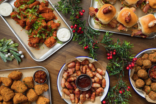 Buffet Table Scene Of Take Out Or Delivery Foods. Pizza, Hamburgers, Fried Chicken And Sides. Above View On A Dark Wood Background.
