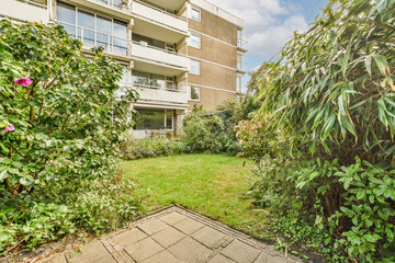 an outside view of a building with plants on the ground and bushes in the fore - eyed area next to...