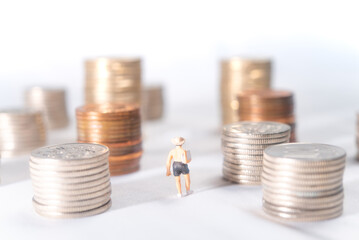 積み上げられた硬貨の間を歩く休暇中の男