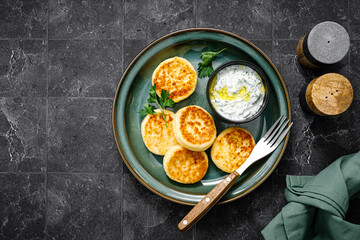 Cottage cheese fritters with greek yogurt tzatziki sauce, top view