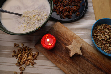 Sweet porridge with poppy seeds and raisins for Christmas by candlelight