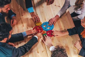 Business team connect pieces of colorful gears like a teamwork and partners