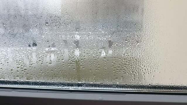 condensation on the window forms droplets flowing on the glass