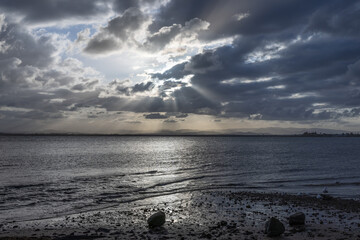 sun rays through thick clouds over the sea