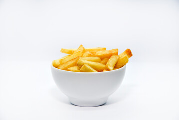 Fototapeta na wymiar Yellow delicious French fries in white dishes. Fast food on a plate. Fried potatoes. Toasted potato slices on a white background.