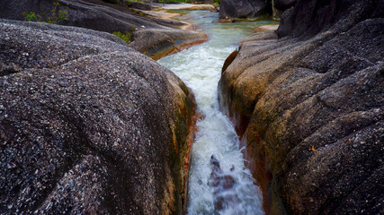close up view, swift river flowing with mountain rock formations