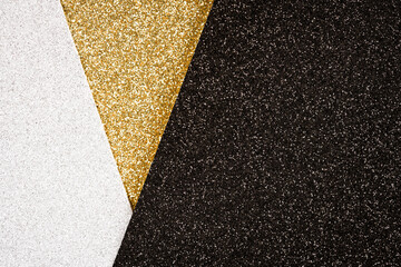 Festive glitter background - abstract geometric composition in golden, black and silver colours with copy space for your text. Minimal fashionable style backdrop. Luxury background