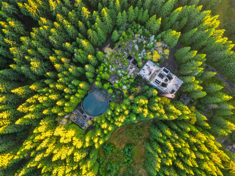 Ruins of former tin mine near Rolava village in the forests of Ore Mountains, Czech Republic. Aerial view from drone.