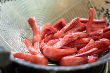 Red sausage cut into pieces and fried in oil.	