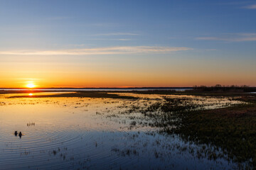 Fototapeta na wymiar Sunset at a lake with a beach and ducks