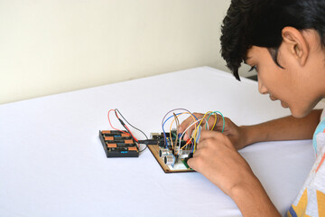 A young boy working on a project involving electric circuits and coding
