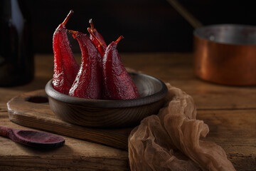 Beaujolais Red wine poached pears in wooden bowl, delicious french dessert