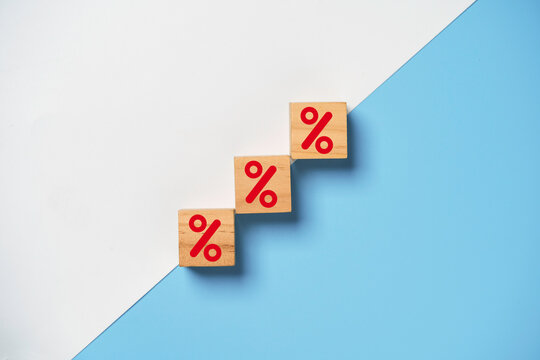 Red percentage sign print screen on wooden cube block on white and blue background for increase financial interest rate and business investment growth from dividend concept.