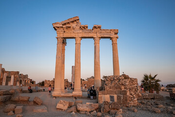 Side, Turkey. October 10, 2022. Low angle view of ancient old ruins of the Temple of Apollo with clear blue sky in the background during sunset