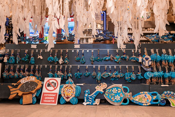 Various blue souvenirs with evil eyes hanging and arranged on wall in shop at Turkish market