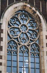 Openwork large round window with stained glass on facade of the building. Baroque and Gothic architecture. Church of St. Olga and Elizabeth. Lviv, Ukraine.