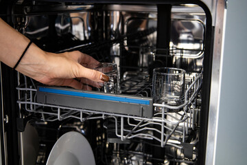 Built-in dishwasher in the kitchen, washing dishes. Plates, cups, glasses are worth washing. Household chores, everyday life