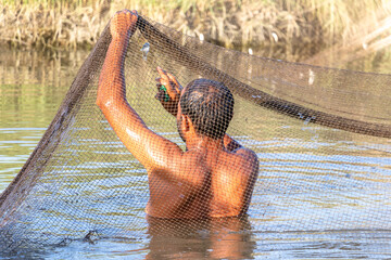 fisherman catching fish by net