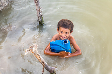 little kid drinking pond water because of sweet drinking water crisis
