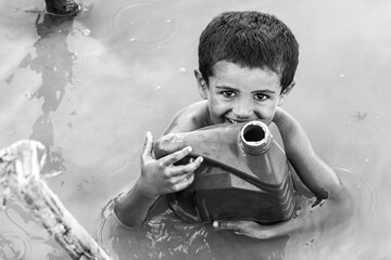 little kid drinking pond water because of sweet drinking water crisis