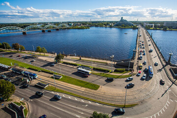 Traffic car bridge over big blue river with cars - Riga, Latvia