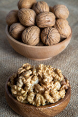 Peeled walnuts and whole walnuts on burlap sack 
