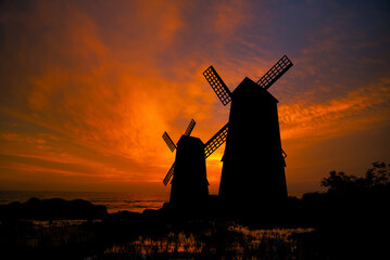 Beautiful landscape photography with traditional Dutch mill near waterways with fantastic sunset