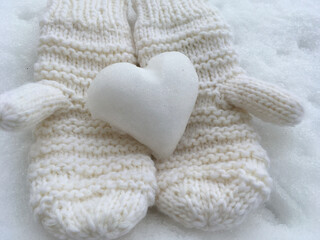 Knitted mittens with heart of snow. 