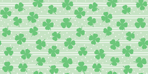 Green shamrocks and clover leaves on a pale green striped background with dots. St. Patrick's Day endless texture. Vector seamless pattern for wrapping paper, giftwrap, cover, surface texture or print